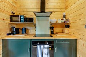a kitchen with a stove in a wooden cabin at Woodlands Lavender Lake House in Long Bennington +20 photos