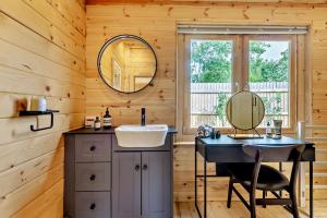 a bathroom with a sink and a mirror at Woodlands Lavender Lake House in Long Bennington