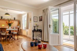 a living room with a table and a dining room at Woodstock in Ventnor
