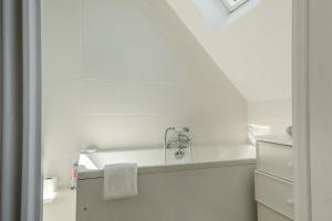 a white bathroom with a sink and a towel at Woodstock in Ventnor +22 photos