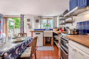 a kitchen with a counter and a table with chairs at Alice Cottage - Corfe Castle in Corfe Castle +14 photos