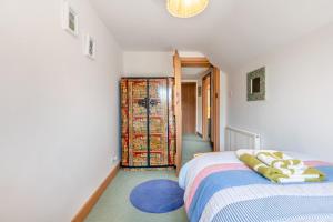 a bedroom with a bed and a door to a closet at Alice Cottage - Corfe Castle in Corfe Castle