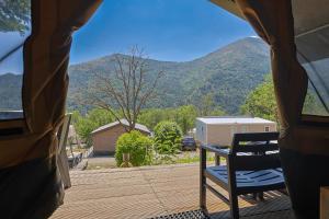 a view of a porch with a chair and mountains at Camping RCN Les Collines de Castellane in Castellane +26 photos