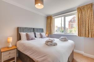 a bedroom with a large bed with towels on it at Flat 1 Deco in Swanage