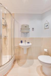a bathroom with a toilet and a sink and a shower at Flat 1 Deco in Swanage