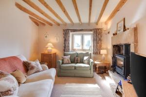 Una sala de estar con un sofá y una chimenea. en Holly Homestead, en Middleton