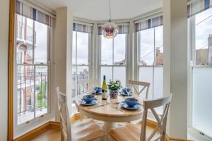 a dining room with a table and chairs and windows at Flat 5 Penlu in Swanage