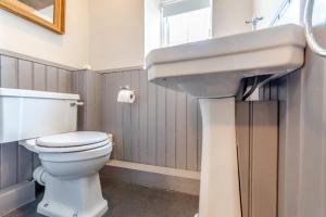 a bathroom with a white sink and a toilet at Rose Cottage in Youlgreave +8 photos