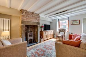 a living room with a fireplace and a tv at Bobbin Cottage in Belper