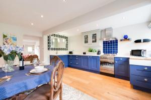 a kitchen with blue cabinets and a table and chairs at Bobbin Cottage in Belper