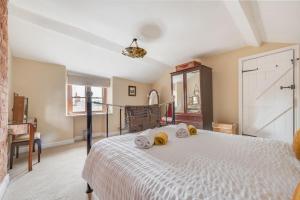 a bedroom with a white bed with towels on it at Bobbin Cottage in Belper