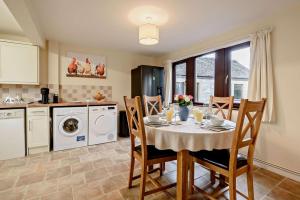 a kitchen with a table and chairs in a kitchen at The Catlow in Parwich