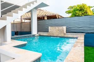 een zwembad met een trap in een huis bij La Casita Blanca - Sun in Fajardo