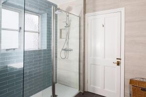 a bathroom with a shower with a glass door at Artists Coastal Retreat in Wool +17 photos