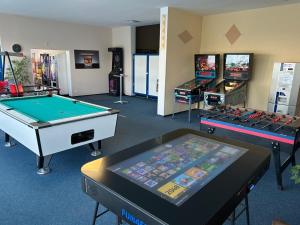 a room with two pool tables and arcade games at Ferienglück Geyersberg in Freyung