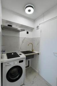 a kitchen with a washing machine and a sink at Paris 16, Lux Studio - Steps from metro 9! in Paris