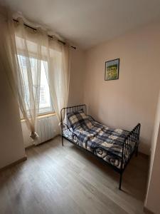 a bedroom with a bed in front of a window at Au Cœur d Orgelet in Orgelet +18 photos