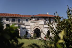 Un gran edificio blanco con una puerta en un patio. en Hôtel Maison Chiberta, en Anglet