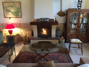a living room with a fireplace and a fire place at Les Ecuries de Montdoucet in Souancé-au-Perche