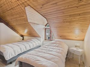 three beds in a room with a wooden ceiling at Maison en pierre avec jardin pour 4 personnes in Erquy