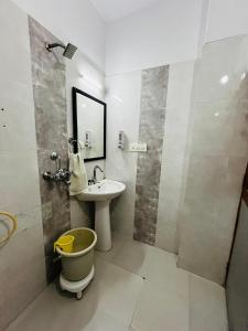 a bathroom with a sink and a toilet and a mirror at Golden Marigold Hotel in Jaisalmer
