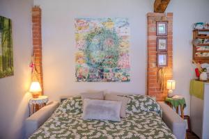 a bedroom with a bed and a painting on the wall at Casa di Cristina - Tra Montepulciano e il Lago Trasimeno in Casamaggiore