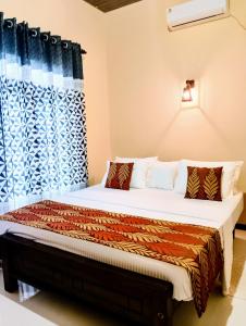 a bedroom with a large bed with a curtain at Sigiri Nethu Home Stay in Sigiriya