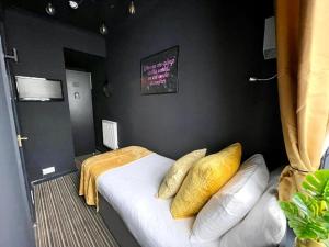 a bedroom with a bed with yellow pillows on it at Blue Skye Guest House 8 in Brighton & Hove +4 photos