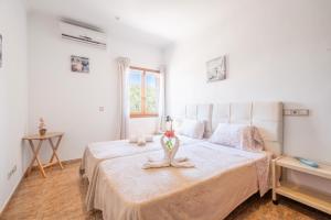 a bedroom with a large white bed with a flower on it at Leon in Portocolom +23 photos
