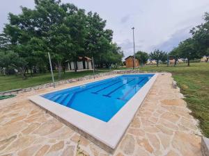 a swimming pool in a yard with trees at Camp Robeko in Skradin