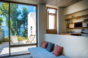 a living room with a couch and a large window at Seafront House in Vathi, Methana in Methana