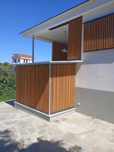 a house with a wooden gate on the side of it at Modern Summer House Kalimera in Epanomi
