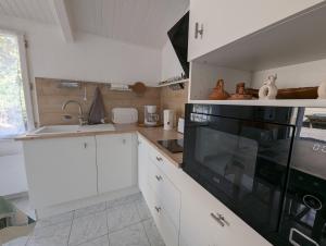 a kitchen with white cabinets and a black stove top oven at Maison du Marais Vendéen in Saint-Benoist-sur-Mer +8 photos