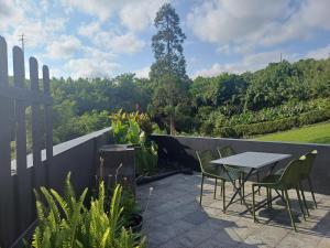 a patio with a table and chairs in a garden at Canada da Ribeira in Ponta Garça
