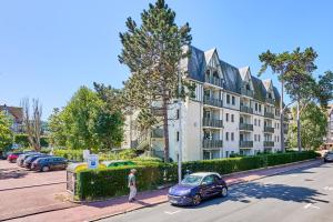 a blue car parked in front of a building at Residence Pierre & Vacances Les Embruns in Deauville