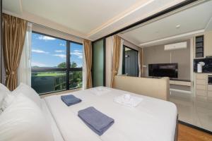 une chambre avec un lit blanc et une grande fenêtre dans l'établissement Panora sea view -modern facilities walk to beach, à Surin Beach 18 autres photos