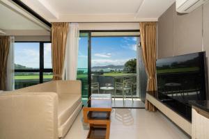 un salon avec un canapé et une grande fenêtre dans l'établissement Panora sea view -modern facilities walk to beach, à Surin Beach