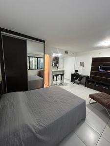 a bedroom with a bed and a desk and a piano at Hotel Moema Shopping Ibirapuera Com Garagem 1420 in Sao Paulo