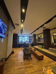 a large living room with couches and a flat screen tv at Hotel Moema Shopping Ibirapuera Com Garagem 1420 in Sao Paulo +44 photos