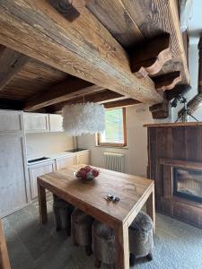 una cucina con tavolo in legno e sgabelli di Appartamento di montagna in puro stile chalet a Breuil-Cervinia