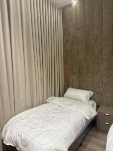 a small bed in a room with curtains at المنزل الآمن in Medina