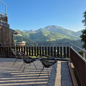 two chairs sitting on a balcony with mountains in the background at Le Terrazze del Sagittario - Top View - PVT Parking in Prato Nevoso +16 photos