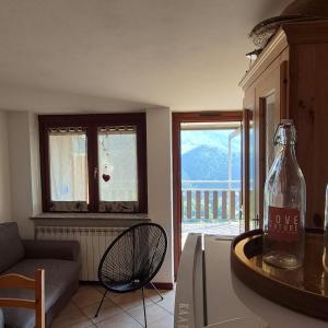a living room with a bottle of wine on a counter at Le Terrazze del Sagittario - Top View - PVT Parking in Prato Nevoso