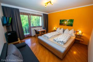 a bedroom with a large bed and a couch at Haus am Kolm in Bad Bleiberg
