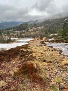 einen Fluss mit Schnee an der Seite eines Berges in der Unterkunft Karíbu-Welcome in Øyuvstad