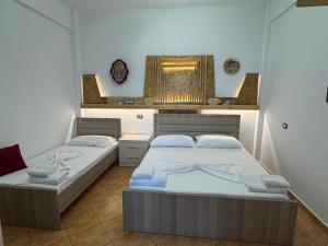 a bedroom with two beds and a window in it at Guest House Toska in Berat