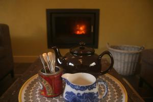 a tea pot and a cup of coffee on a table at Creatively converted barn in accessible rural spot in Llanwrda