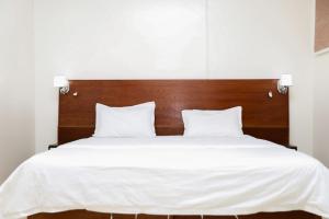 un lit avec des draps blancs et une tête de lit en bois dans l'établissement شقق ليال الربيع Lial alrabe, à Az Zulfi 6 autres photos