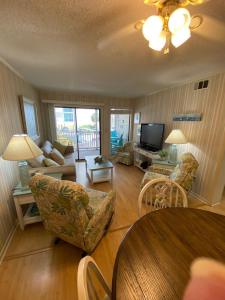 a living room with a table and chairs and a television at Seasons In The Sun in North Myrtle Beach