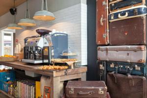 eine Bäckerei mit Kaffeemaschine auf einem Tisch mit Gepäck in der Unterkunft Van Heeckeren Hotel in Nes
